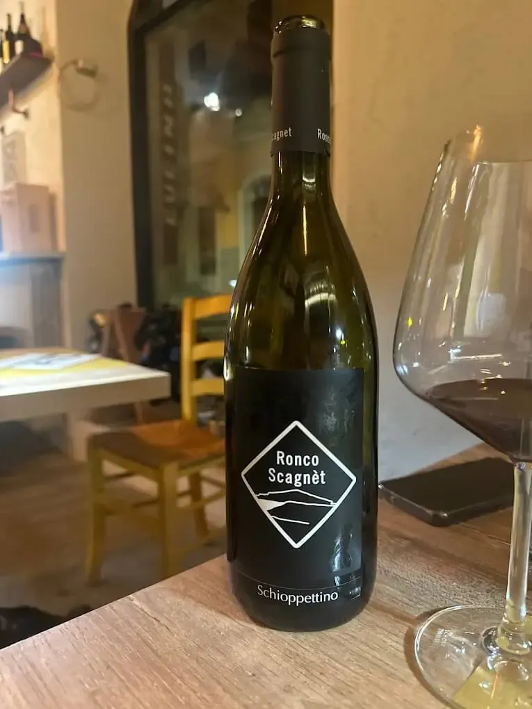 Calice di vino rosso con piatto del Sancarlino
